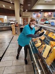 woman scrubbing a glass food display